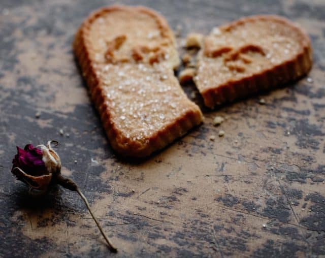 broken heart shaped cookie with a dying red rose on the side | divorce | financial independence