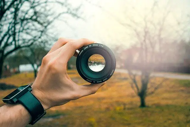 Hand holding a camera lens with an autumnal background | What is my focus for 2021
