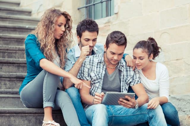 Group of Friends sitting on steps with Tablet PC