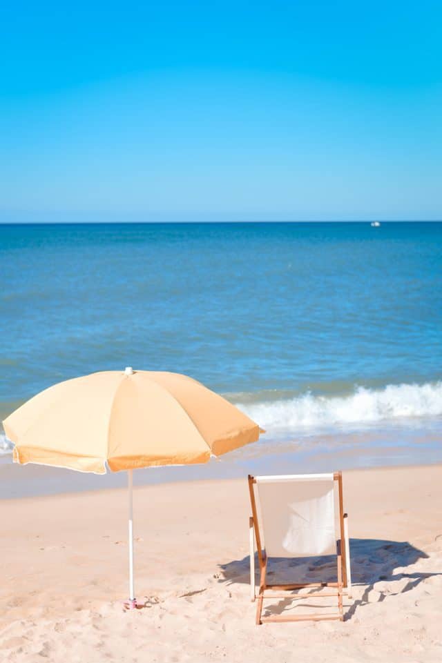 Back view of deck chair and umbrella on a beach