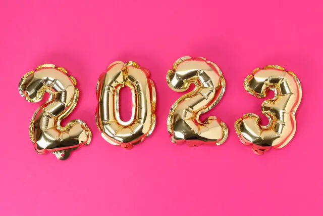 Foil balloons numbers 2023 on a pink background.